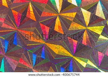Multicolored psychedelic abstract formed by light reflecting off a textured metal surface