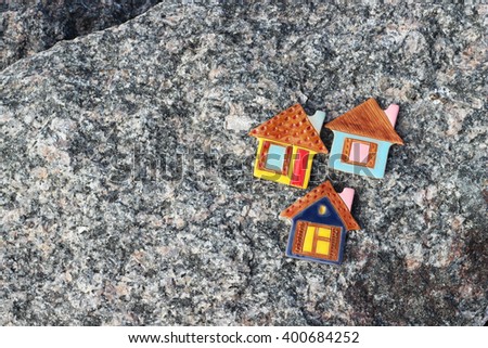 real estate, toy houses on big stone
