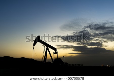 Sunset and silhouette of crude oil pump in oilfield - Bahrain
