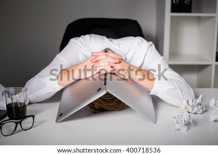 Man hiding under laptop  Royalty-Free Stock Photo #400718536