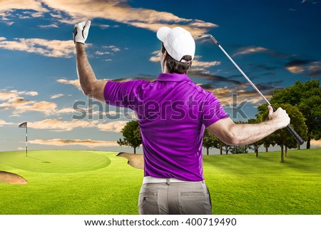 Golf Player in a pink shirt celebrating, on a golf course.