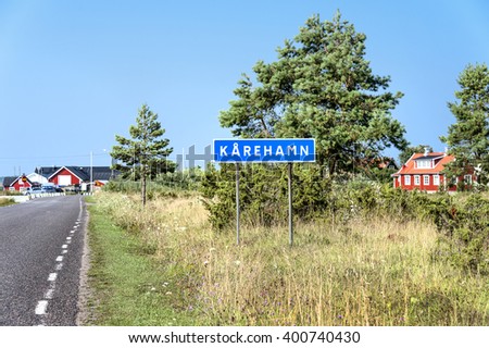 Sweden, Karehamn: Street scene with empty road and blue city sign to the Swedish small fishing village town and red traditional houses near the Baltic Sea coast. 