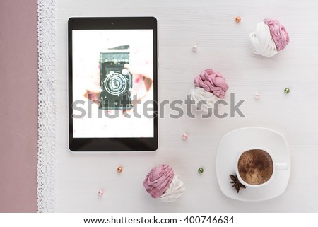 handmade marshmallows next Cup of coffee and a tablet with a picture of the camera