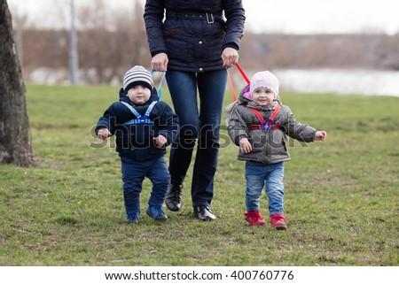 Young mother walking with her two children off the leash