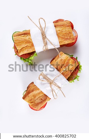 deli sandwiches in paper wrap /top view Royalty-Free Stock Photo #400825702