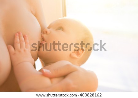 happy mother breast feeding her baby infant. Mom nursing baby. Woman and new born boy relax. Mother breast feeding baby. Family at home