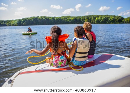 Family tubing from a boat on an inland lake Royalty-Free Stock Photo #400863919