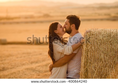 Happy young adult couple outdoors kissing and smiling