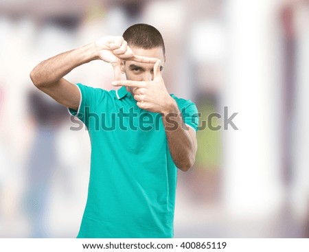 Young man taking a photo with his hands