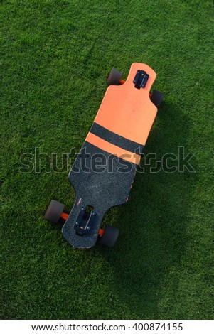 longboard orange grass. Black and orange longboard on a green lawn grass