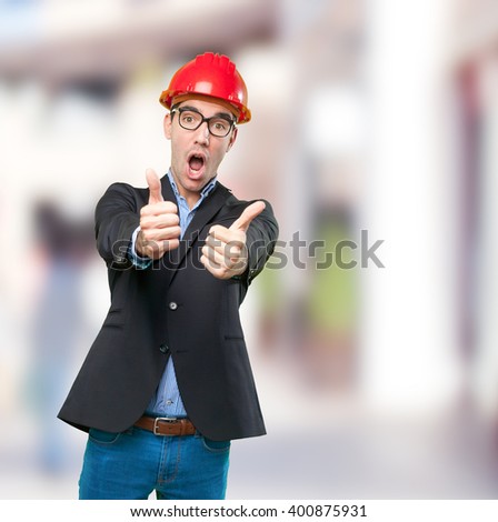 Surprised young architect with thumbs up