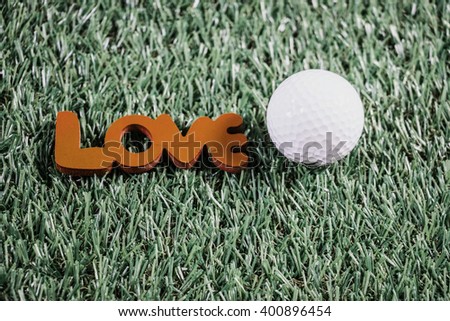 Golf ball with love letter are on green grass