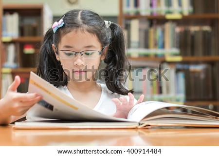 School education and literacy concept with young Asian girl student, smart kid in elementary grade learning, studying hard or reading children's picture book in library or classroom