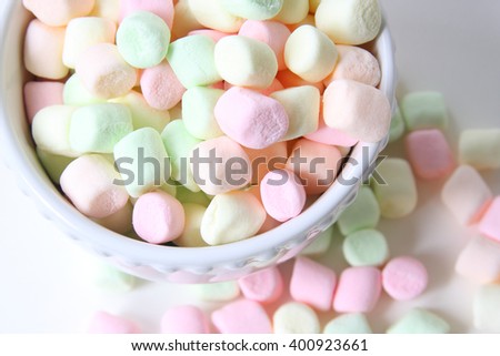 White bowl of colored marshmallows, isolated on white background 