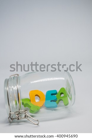 Wooden alphabet IDEA word in the glass bottle with white background in Vertical view and selective focus