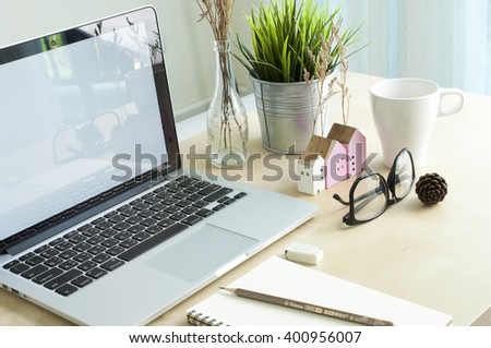 Laptop white screen with blank note book in creative work office