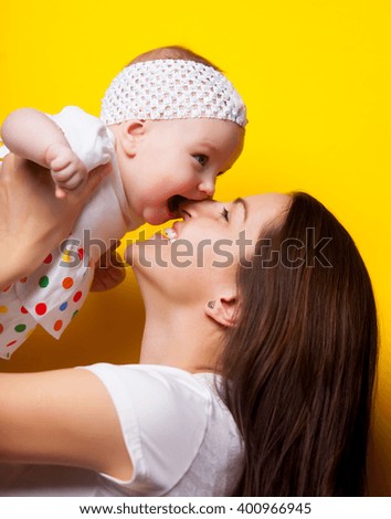 photo of happy mother and daughter on the yellow background