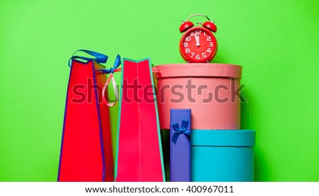 colorful packets and alarm clock  on the green background