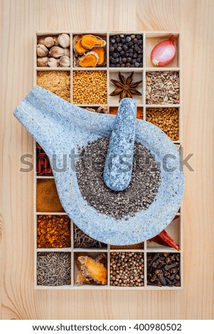 Assortment of spices food cooking ingredients in wooden box and mortar  set up on wooden table.