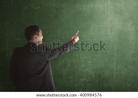 Business man show something with chalkboard background. you can put your design on the board