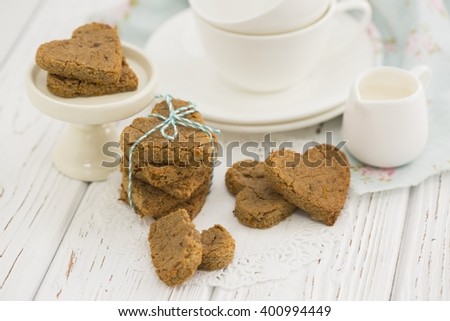Cute Valentine heart biscuits next to tea set. Oatmeal cookies.