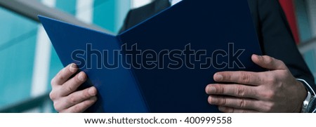 Cropped picture of a man holding a file