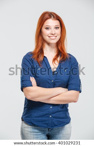 Happy attractive redhead young woman standing with arms crossed over white background