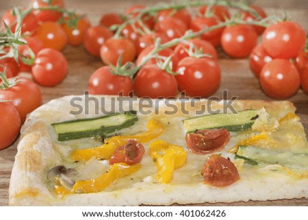 slice of homemade vegetarian pizza with zucchini and cherry tomatoes