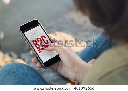 woman holding a smartphone and touching the screen shoing b2c marketing concept. All screen graphics are made up.
