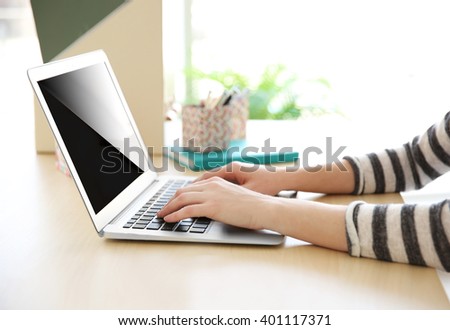 Woman working with laptop at home or at office
