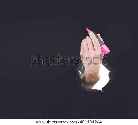 Male hand breaking through the gray paper background and holding key in red box