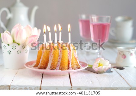 coffee table with birthday cake, candles and tulips