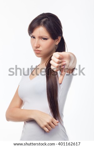Portrait of beautiful young woman gesturing thumbs down on white background