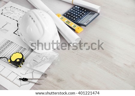 Blueprints and white helmet, close up Royalty-Free Stock Photo #401221474