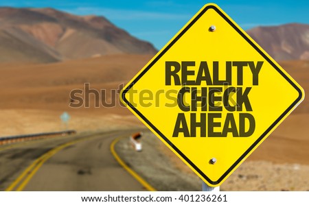 Reality Check Ahead sign on desert road Royalty-Free Stock Photo #401236261