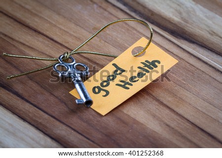 concept for a happy healthy life using an old decorative key and a hand written tag attached by a golden cord