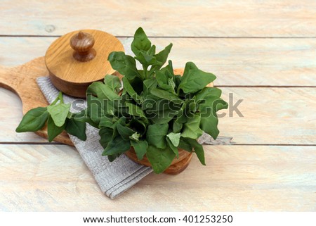 Fresh spinach in a wooden bath on the table