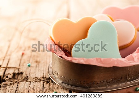 Festive heart shaped fondant cookies with colorful glazing on a rustic wooden table with copy space to celebrate Valentines Day, anniversary or wedding