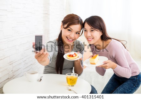 Two beautiful woman having dessert together in coffee shop