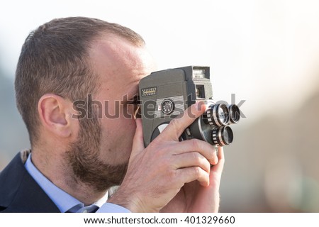 Businessman outdoor with a vintage film camera