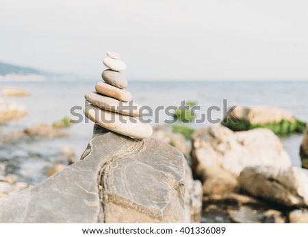 Stones pyramid on coast on background of sea
