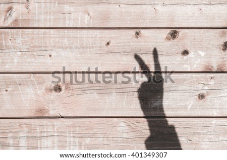Shadow in shape of peace symbol on an old wooden background