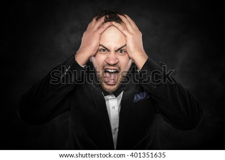 Angry businessman shouting or screaming over dark background.