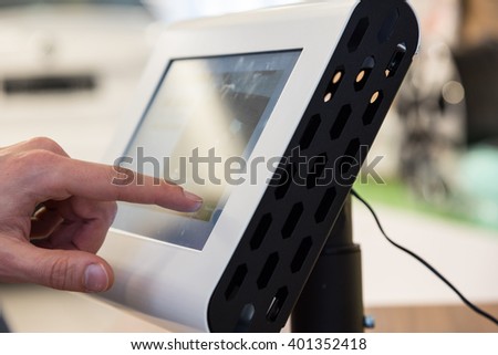 A finger touching a thick touch screen device