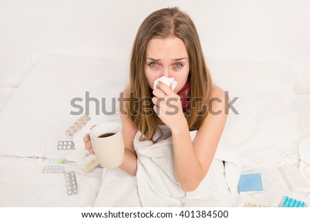 Sick woman with rheum holding a cup of hot tea Royalty-Free Stock Photo #401384500