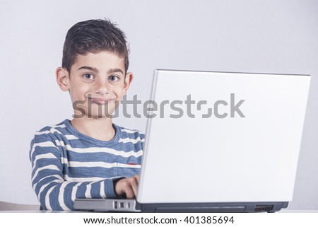 Young boy using a laptop computer (e learning concept). Toned image with selective focus