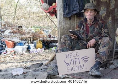 homeless man holds a paper cardboard sign that reads "need wifi signal"