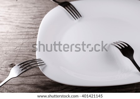 Plate and forks on a wooden background