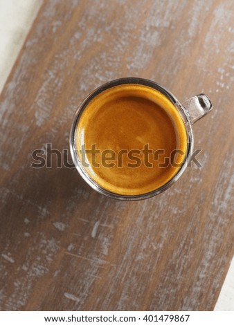 Cup of hot espresso coffee on wood table, background