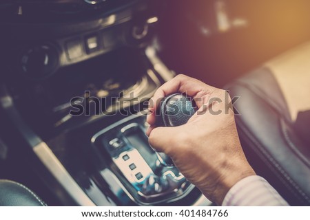 Business man driver hand shifting the gear stick. Vintage filter Royalty-Free Stock Photo #401484766